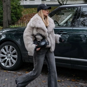 Close-up of short faux fur jacket in taupe with wide lapels on a fashion model