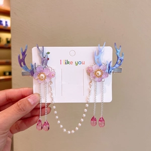Detail of deer horn hair clip with purple gradient, resin flowers and pearl tassel