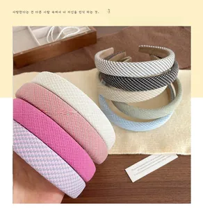 Detail of woven fabric sponge headbands in various colors on a wooden table setup