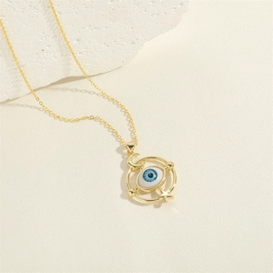Golden Evil Eye pendant necklace with moon and star charms on a white stone background