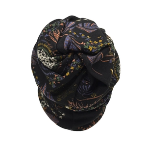 Detail view of a black patterned slouchy beanie with colorful ethnic floral print