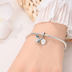 Silver firefly pendant snake chain bracelet with colored zircons on model wrist