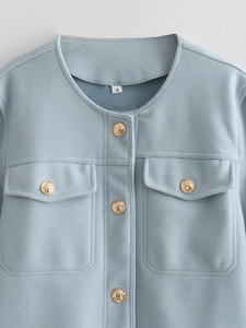 Close-up of light blue tweed jacket featuring golden embossed buttons and a front pocket