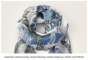 Macro shot of silk-like floral scarf fabric showing detailed blue and green botanical patterns