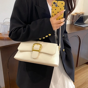 Detail of off-white lychee texture leather shoulder bag with gold metal buckle accents