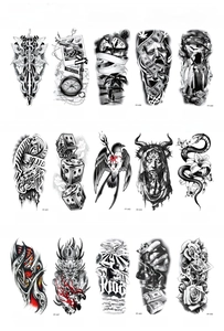 Macro shot of 15 large black and white temporary tattoo sheets with diverse wolf and compass designs