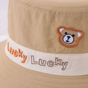Détail de la broderie ours et du ruban 'Lucky Lucky' sur le chapeau enfant kaki