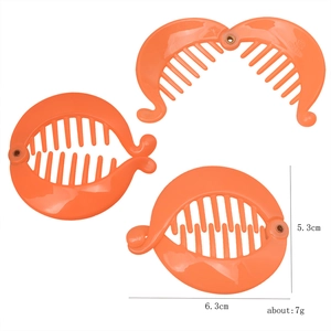 Macro detail of an orange fish-shaped banana hair clip showing its 6.3cm size and multi-teeth