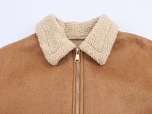 Détail de la veste en daim marron avec col en peau de mouton blanche et fermeture éclair