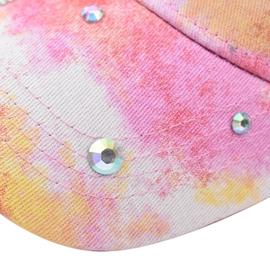 Close-up of pink and orange tie-dye baseball cap with colorful rhinestones and stitching