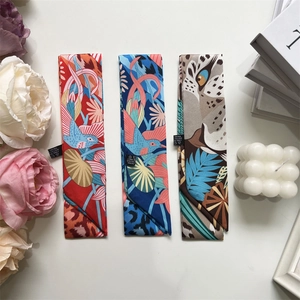 Close-up of floral and leopard print silk scarves styled with elegant lifestyle props