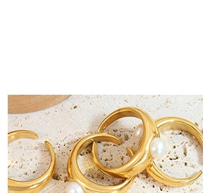 Detailed macro view of gold-plated adjustable rings with minimalist pearl inlay design