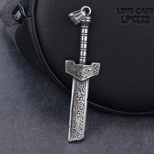 Detailed close-up of a vintage silver sword pendant with Nordic engraved patterns and mask relief