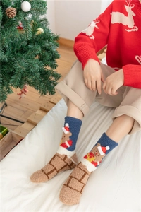 Close-up of thick coral fleece Christmas socks featuring 3D holiday themed decorations