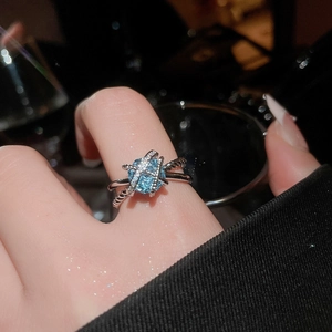 Detail of twisted silver ring with sky blue cushion-cut stone and micro-pave accents