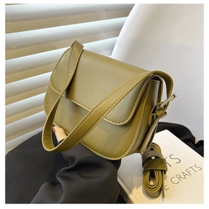 Detail shot of an olive green leather saddle bag on an aesthetic lifestyle background