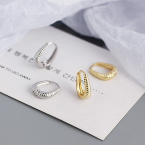 Detailed close-up of S925 sterling silver twist hoop earrings with spiral texture finish