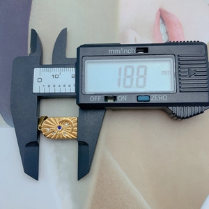 Detailed measurement of 18.8 mm golden sunburst pendant with blue stone and small gems