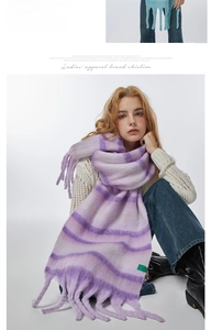 Close-up of thick striped knit scarf with long tassels in purple and soft pink shades