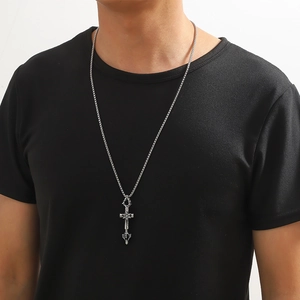 Détail du pendentif épée croix en acier inoxydable argenté porté par un mannequin masculin