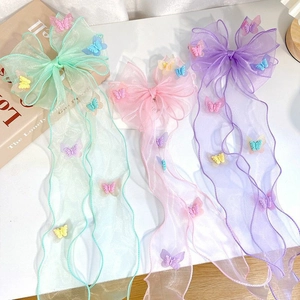 Detailed view of light organza bow hair clips with butterfly appliqués in pink and purple