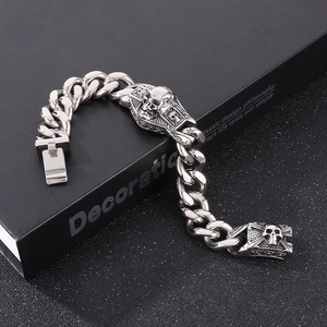 Détail de crânes argentés punk vintage sur un bracelet gourmette épais en acier