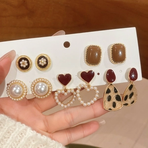 Close-up of 6-pair vintage earring set with resin pearls and heart charms on display