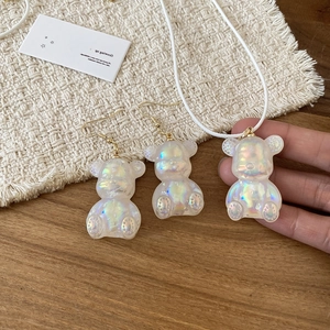 Detailed view of iridescent resin bear earrings and pendant necklace jewelry set