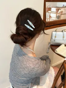Model wearing a light blue enamel dog hair clip with egg text decoration