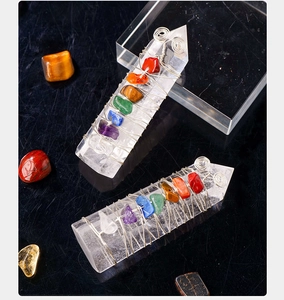 Macro view of crystal energy columns with hand-woven colorful stones on black background