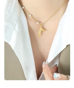 Close-up of elegant gold mermaid tail pendant necklace with pearls on a model