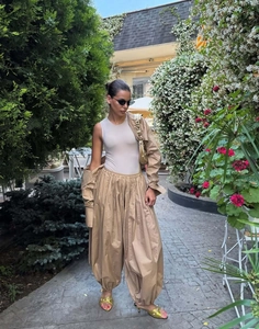 Close-up of khaki lantern pants paired with a matching loose shirt in a garden setting