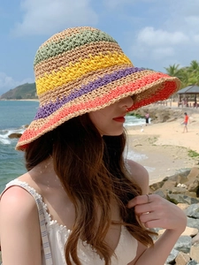 Detail of colorful striped straw hat featuring bright green, yellow, and purple woven patterns