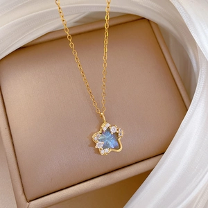Macro view of gold star pendant with blue gemstone inlay resting on silk fabric