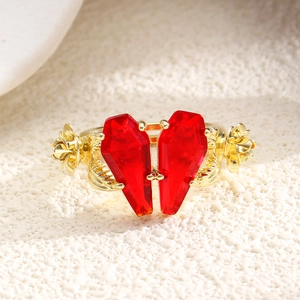 Detail of red coffin crystal ring featuring golden roses and gothic skeleton hand design