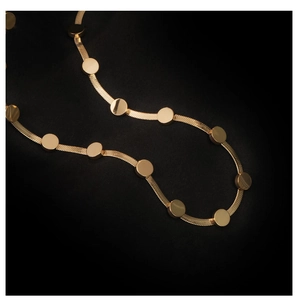 Detail of gold snake chain necklace with polished round disc pendants on black satin