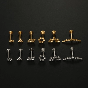 Detailed set of 12 gold and silver 16G stainless steel labret studs with various bead designs