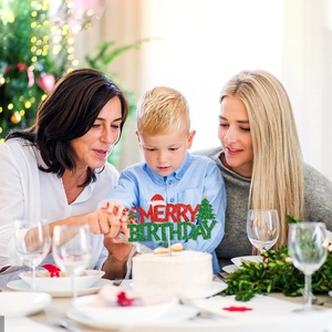 Glittery Merry Birthday cake topper with Christmas tree and hat in a cozy family setting