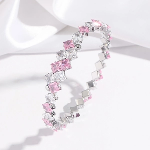 Detail view of square pink and white zircon gemstones on a polished silver metal bracelet