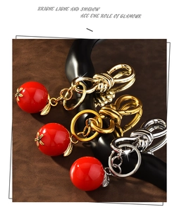 Detail view of red resin cherry charms with polished gold and silver metallic buckles