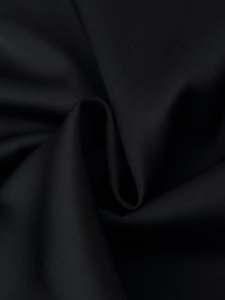Close-up of premium black satin fabric texture showing smooth finish and soft drape