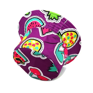 Dettaglio del cappello alla pescatora in twill viola con motivi di frutta colorati