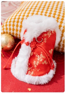 Close-up of festive red pet vest with gold plum embroidery and soft white plush collar