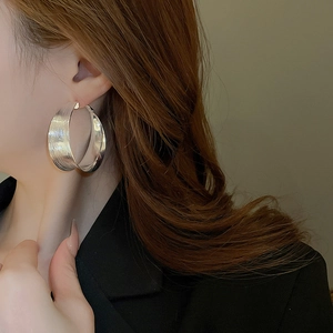Detailed view of silver minimalist pleated hoop earring on model with matte finish