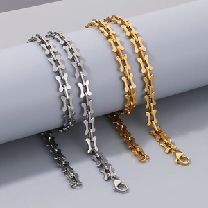 Detail of bone-shaped link chain in gold and silver finish with lobster clasp