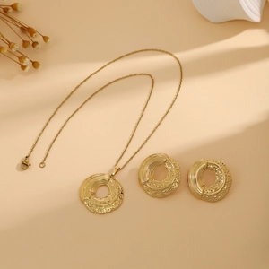 Detailed macro view of gold jewelry set with hammered texture and artistic ripple design
