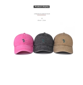 Detail view of washed cotton baseball caps with embroidered palm tree in three colors