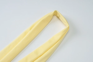 Détail de la maille haute élasticité et des coutures sur la robe jaune à manches longues