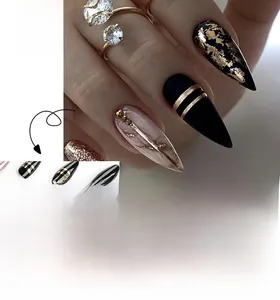 Detail of long almond black and gold press-on nails with foil leaf and double line accents