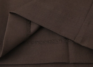 Close-up of deep brown twill fabric texture and neat overlock stitching details